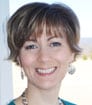 Headshot of smiling author KS with cropped brown hair and earrings